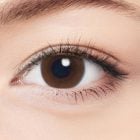 A woman wears neoism coco brown 1-day colored contact lenses on her eyes.
